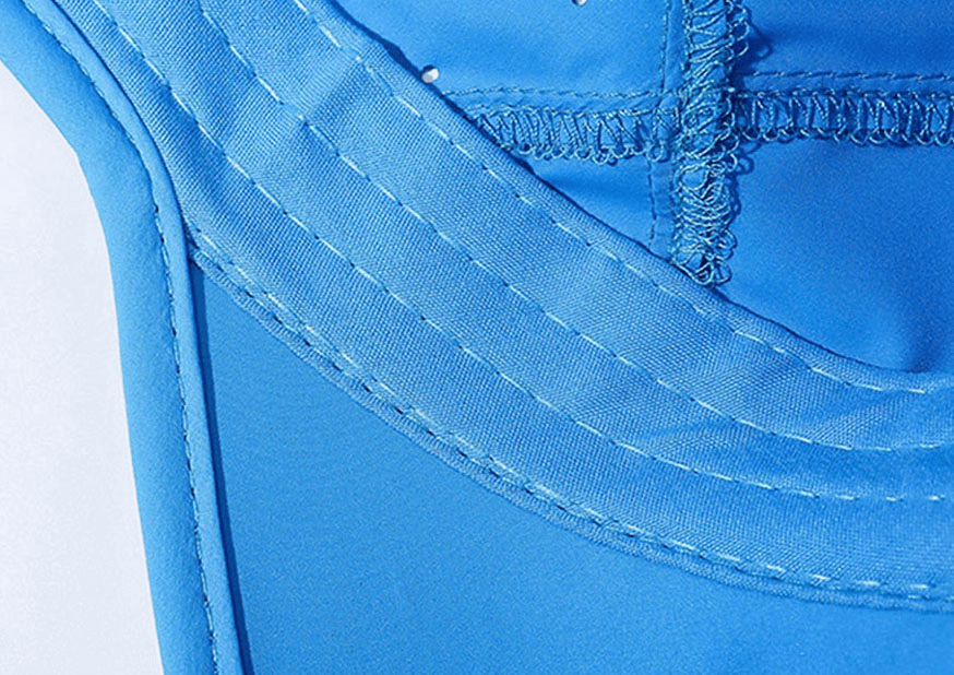 Close-up of a blue waterproof breathable baseball cap's stitching and polyester material, highlighting craftsmanship and durability.